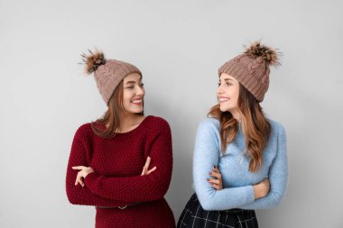 Hafif arka planda kalın kazaklı genç kadınlar.