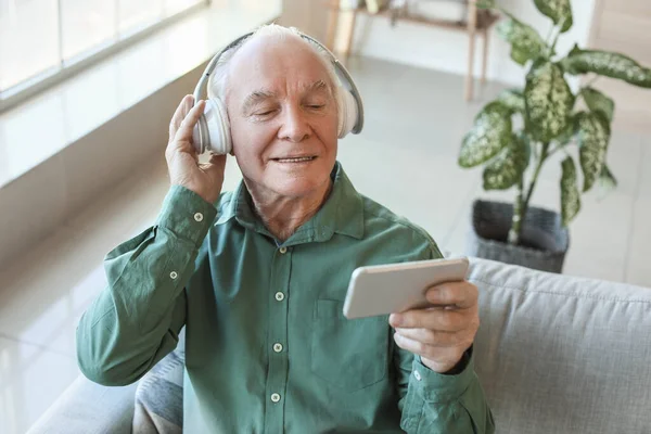 Oudere Man Met Mobiele Telefoon Hoofdtelefoon Thuis — Stockfoto