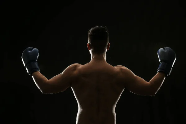 Silhouette of male boxer on dark background