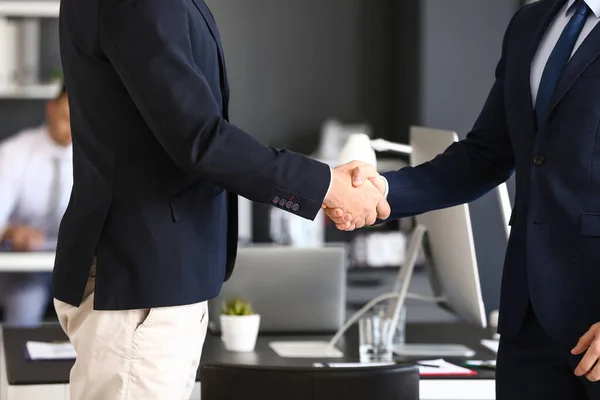 Businessmen shaking hands during meeting in office