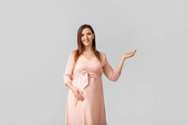 Gri arka planda güzel hamile kadın