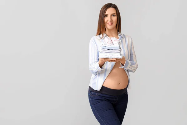 Belle Femme Enceinte Avec Des Vêtements Bébé Sur Fond Gris — Photo