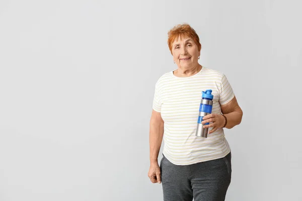 Ältere Frau Mit Flasche Wasser Auf Hellem Hintergrund — Stockfoto