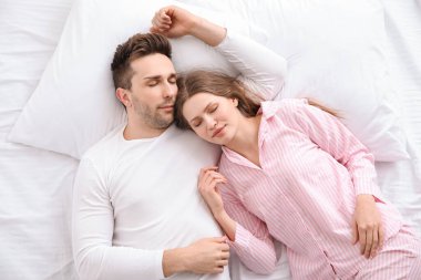 Genç çift yatakta uyuyor.