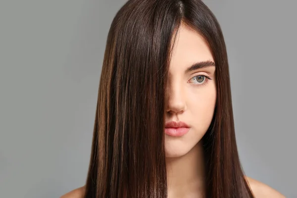 Gri Arka Planda Güzel Düz Saçları Olan Genç Bir Kadın — Stok fotoğraf
