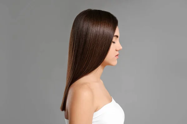 Junge Frau Mit Schönen Glatten Haaren Auf Grauem Hintergrund — Stockfoto