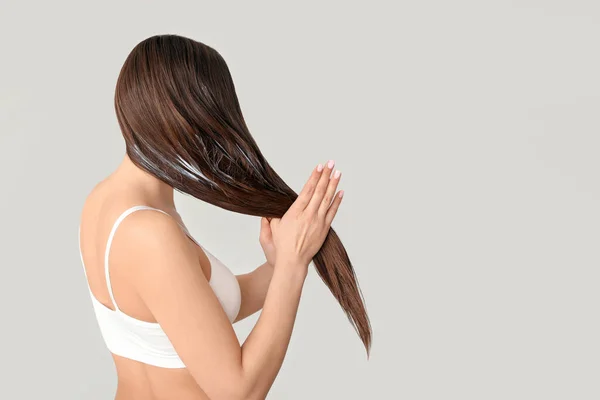 Mulher Bonita Aplicando Óleo Coco Seu Cabelo Contra Fundo Cinza — Fotografia de Stock