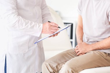 Genç adam ürolojisti klinikte ziyaret ediyor.