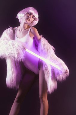Koyu arkaplanda neon lambalı güzel bir kadının tonlu portresi.