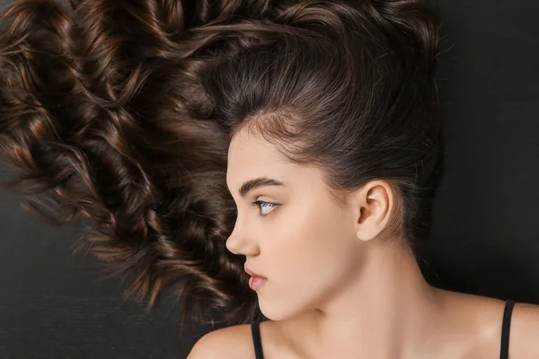 Junge Frau Mit Schönen Lockigen Haaren Auf Dunklem Hintergrund — Stockfoto