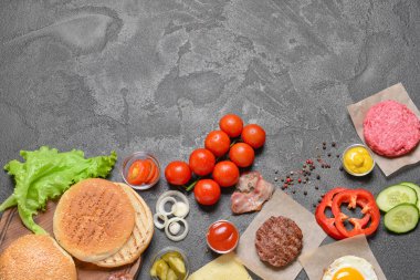 Koyu arkaplanda lezzetli burger için malzemeler