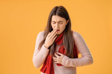 Renkli arka planda öksüren genç kadın