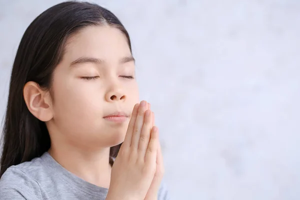 Niedliche Kleine Asiatische Mädchen Beten Auf Licht Hintergrund — Stockfoto