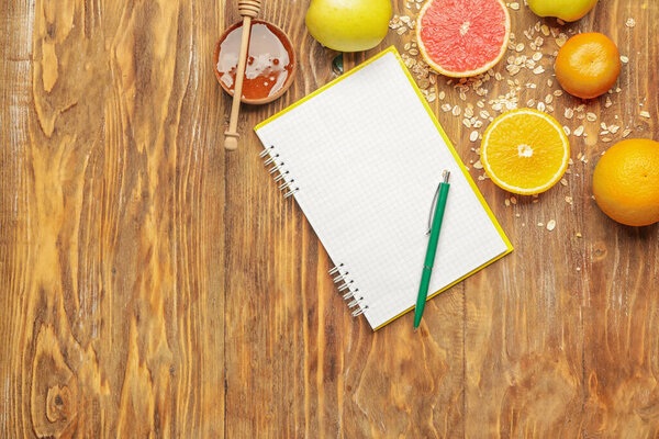 Ноутбук с ручкой и здоровыми продуктами на столе
