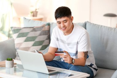Asyalı adam internetten alışveriş yapıyor