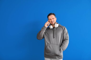 Renkli arka planda cep telefonuyla konuşan şık bir adam