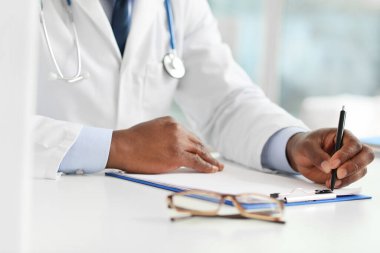 Erkek Afro-Amerikan doktor klinikte çalışıyor, yakın plan.