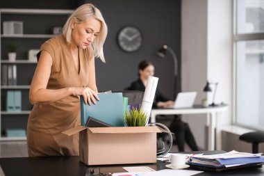 Ofisinde kişisel eşyaları olan üzgün, olgun bir kadın kovuldu.