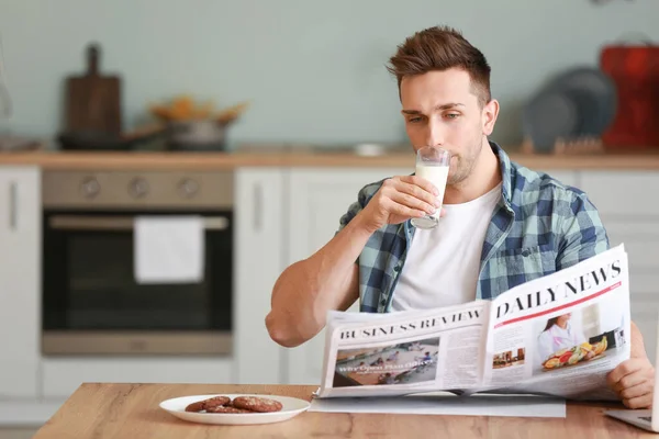 Mladý Muž Čtení Novin Při Pití Mléka Kuchyni — Stock fotografie