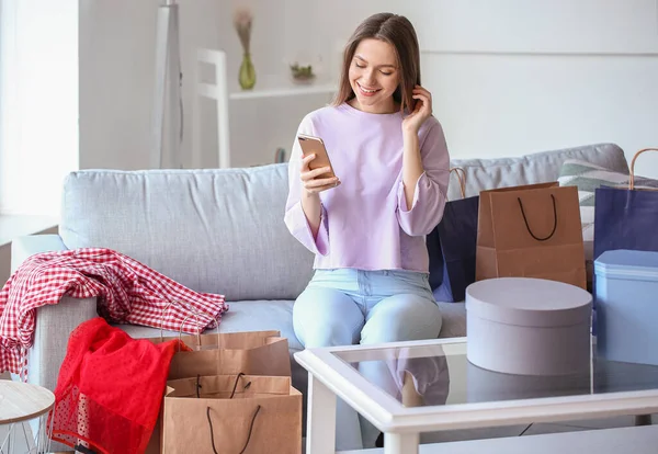 Mladá Žena Mobilním Telefonem Nákupními Taškami Doma — Stock fotografie