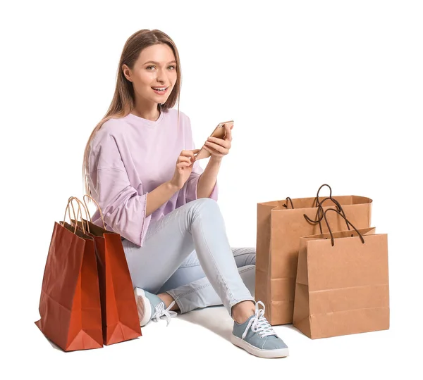 Jonge Vrouw Met Mobiele Telefoon Boodschappentassen Witte Achtergrond — Stockfoto