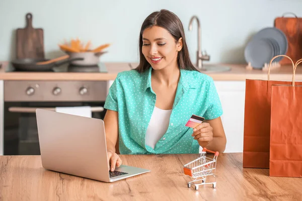 Young woman with laptop and credit card at home. Online shopping concept