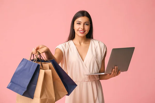 Jonge Vrouw Met Laptop Boodschappentassen Kleur Achtergrond — Stockfoto