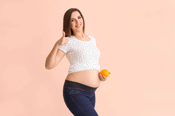 Schöne Schwangere Frau Mit Orange Auf Farbigem Hintergrund — Stockfoto