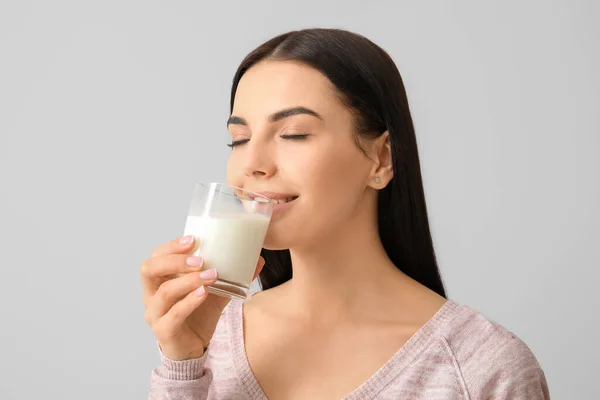 Schöne Junge Frau Trinkt Milch Auf Hellem Hintergrund — Stockfoto