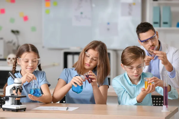 Pupils at chemistry lesson in classroom