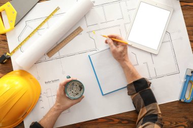 Erkek müteahhit ev planıyla çalışıyor.