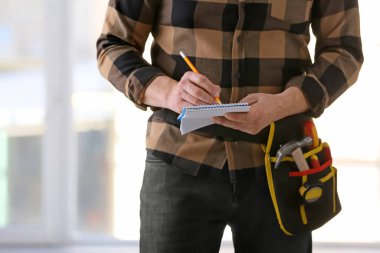 Ofisinde not defteri olan bir erkek müteahhit.