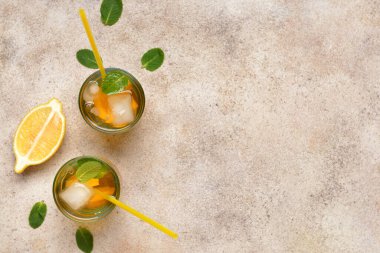 Gri arkaplanda lezzetli soğuk çay bardakları