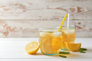 Beyaz ahşap zemin üzerinde lezzetli soğuk buzlu çay bardakları