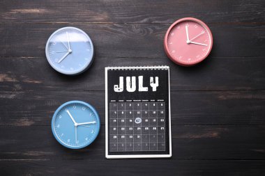 Ahşap zemin üzerinde tarih yazan saatler ve takvimler. Zaman yönetimi kavramı