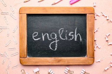 Renk arkaplanı üzerinde ENGLISH ve kırtasiye içeren tebeşir tahtası