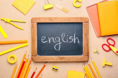 Renk arkaplanı üzerinde ENGLISH ve kırtasiye içeren tebeşir tahtası