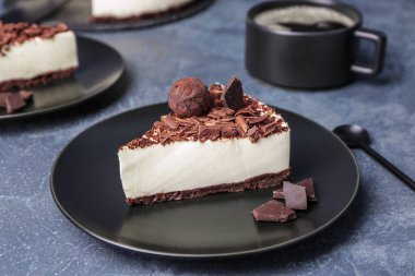 Koyu renkli arka planda lezzetli çikolatalı cheesecake tabağı.