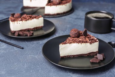 Koyu renkli arka planda lezzetli çikolatalı cheesecake tabakları.