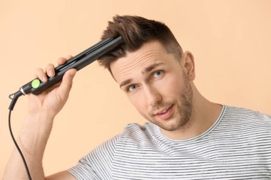 Renk arka planında düz demiri olan yakışıklı bir genç.