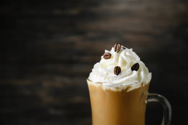 Koyu arkaplanda bir bardak lezzetli buzlu kahve