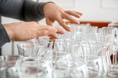 Evde suyla bardakta müzik çalan genç adam, yakın plan.