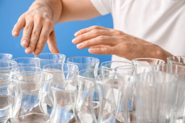 Gözlüklerle müzik çalan genç adam, arka planda suyla birlikte, yakın plan