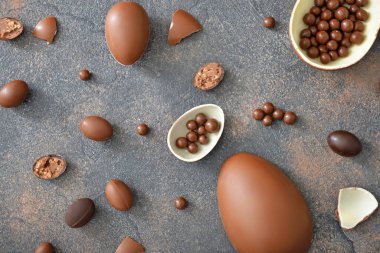 Gri masada çikolata yumurtaları ve şekerler.