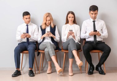 Genç iş adamları ışık duvarının yanında sıra bekliyor.