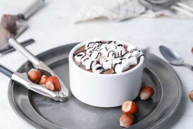 Bir fincan sıcak çikolata, marşmelov ve fındık.