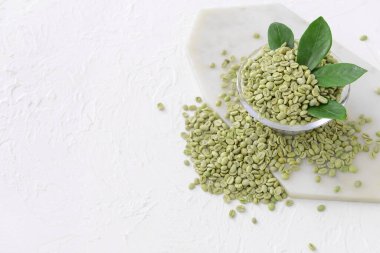 Beyaz arka planda yeşil kahve çekirdekli kase