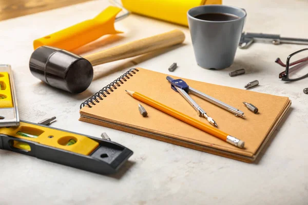 Builder's tools with notebook on white background