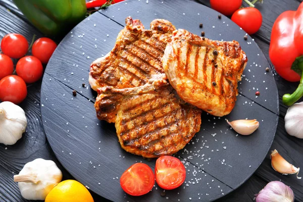 Planche Avec Steaks Porc Cuits Légumes Frais Sur Table — Photo