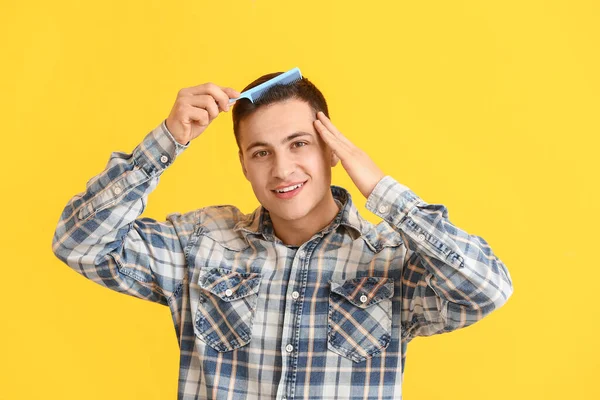 Schöner Junger Mann Kämmt Haare Auf Farbigem Hintergrund — Stockfoto